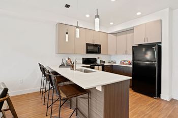 A kitchen with a white counter top and black appliances.